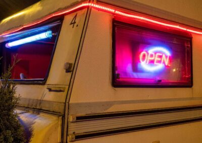 Beleuchtetes Open-Schild in einem Wohnwagen für Prostitution